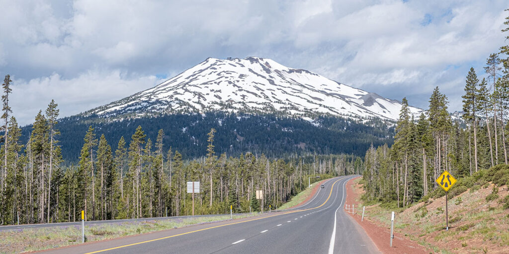 Open road heading toward a snow-covered mountain, supported by an RV Wi-Fi router for remote travel.