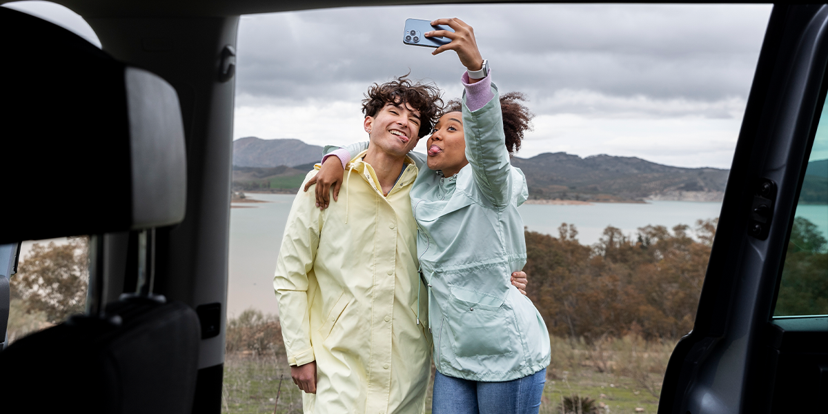 A happy couple sharing travel photos online thanks to a stable and secure RV internet setup while on the road.