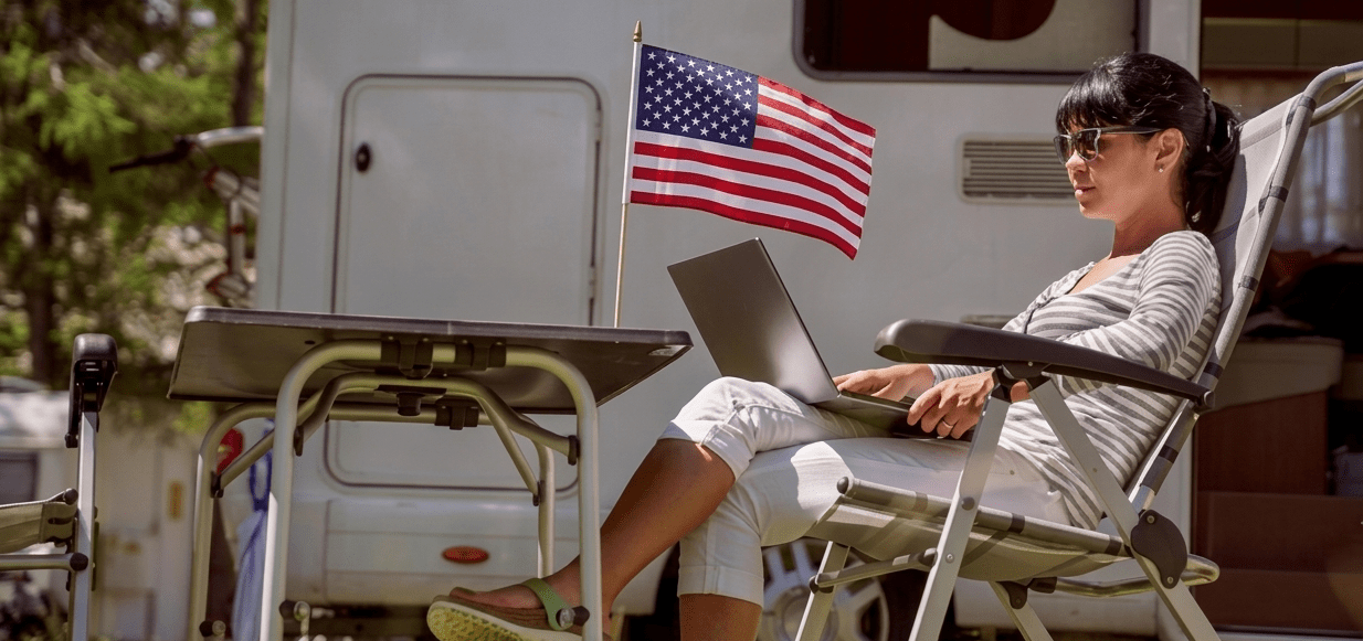An RVer working on a laptop beside her motorhome at a campground over the Labor Day holiday weekend.